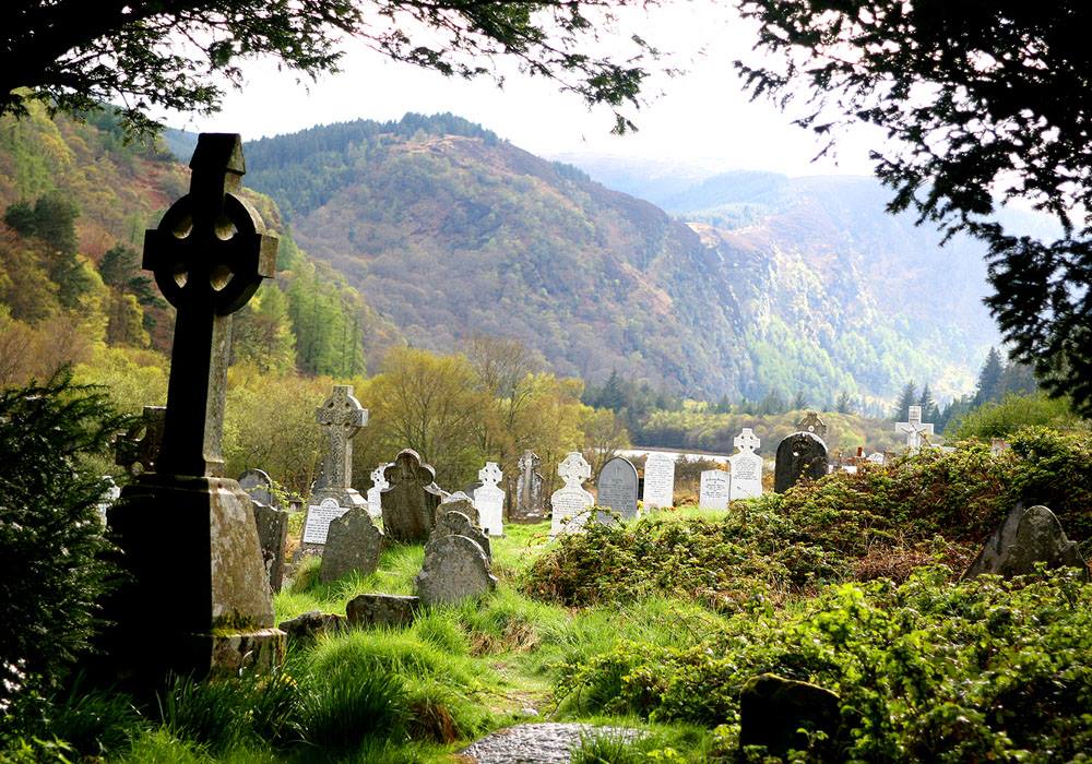 Memorial stones and cross monument in a landscaped setting.